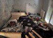Chambre encombrée de mobilier et d’objets avant intervention