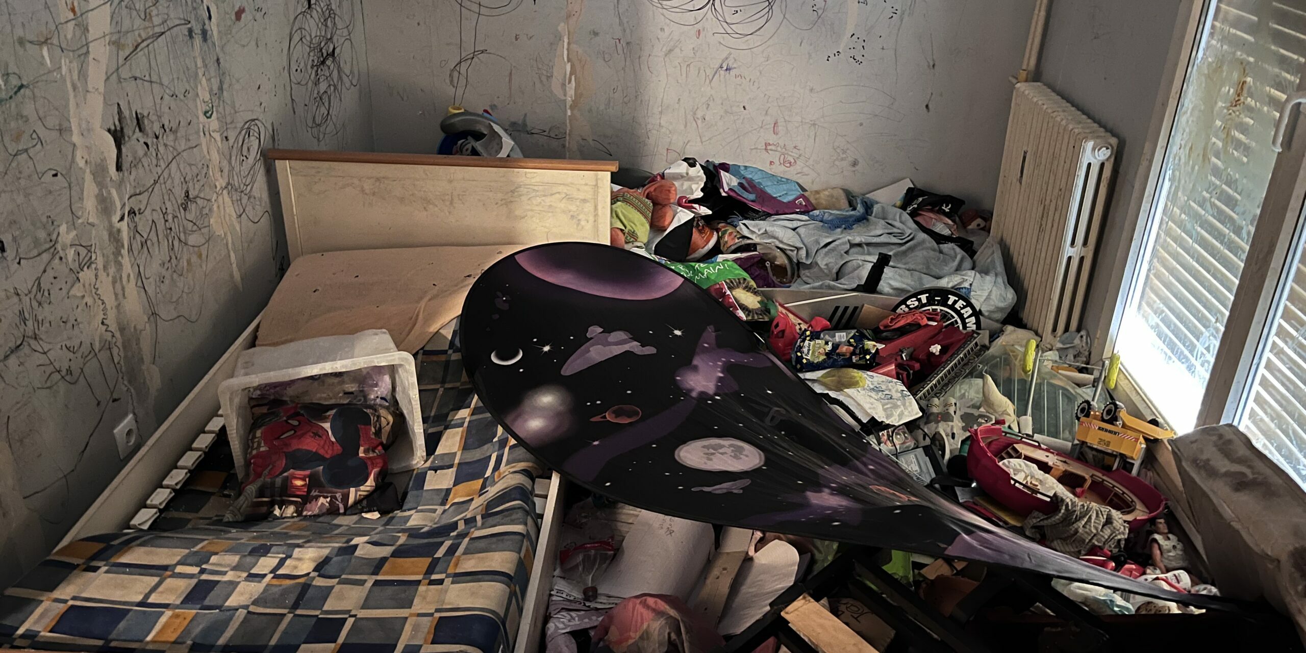 Chambre avant débarras Chambre encombrée de mobilier et d’objets avant intervention