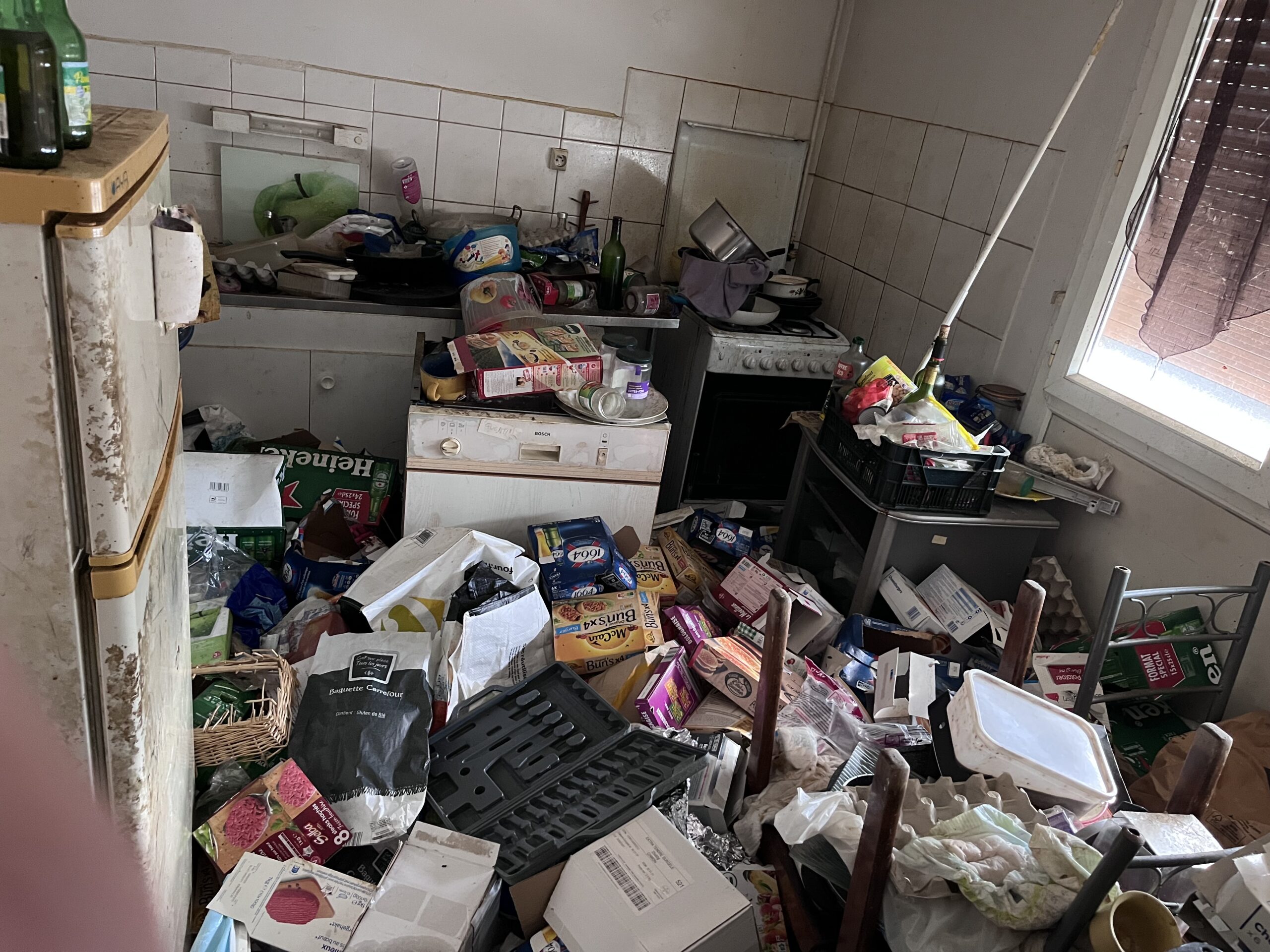 Cuisine encombrée d’objets et d’emballages avant le débarras par Sinope Service