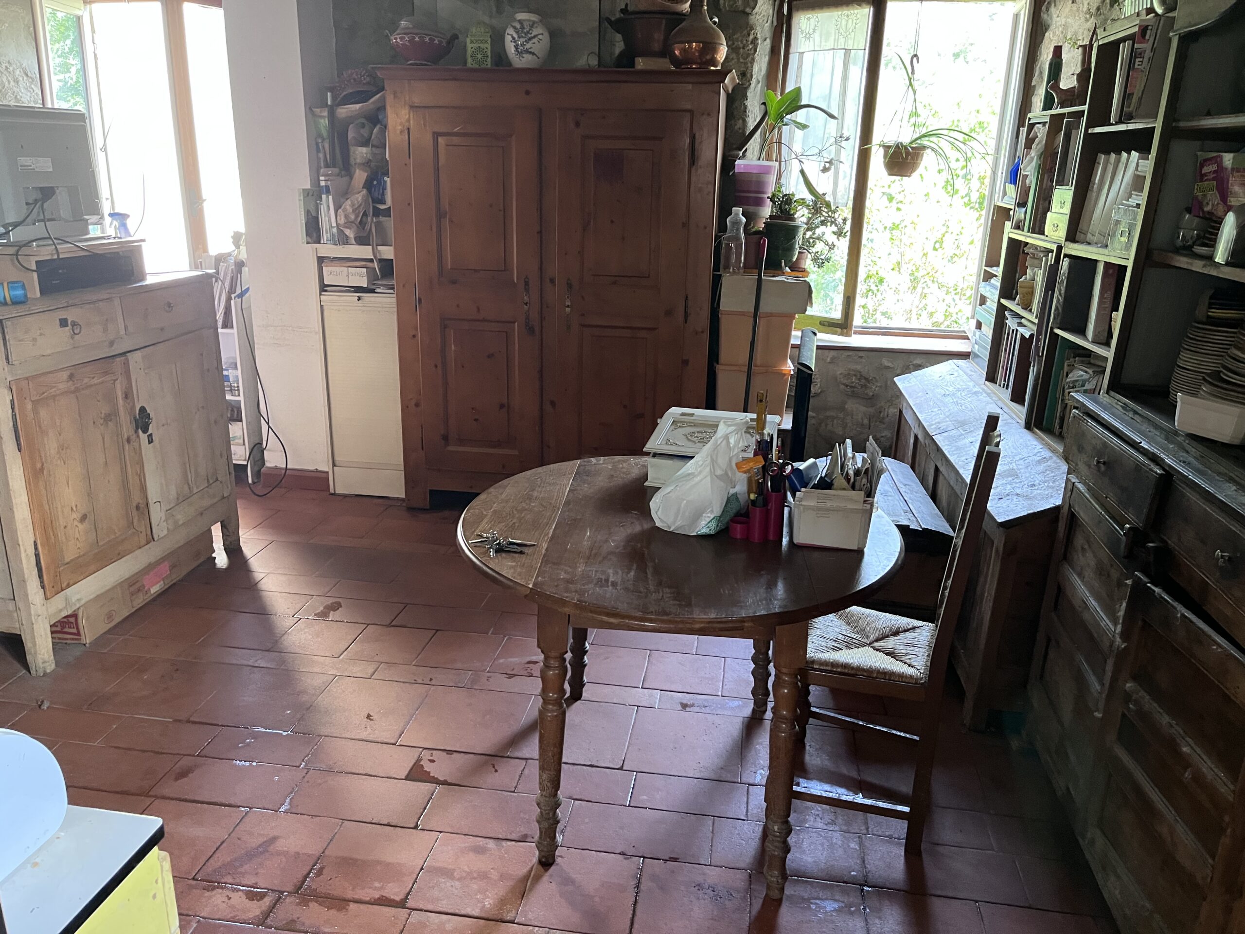Pièce après le débarras, avec les passages dégagés et le mobilier conservé.